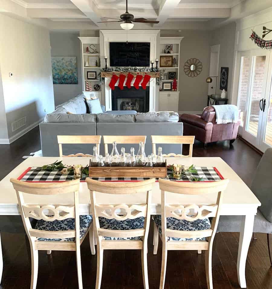 Cozy living room and dining area with Christmas stockings, festive decorations, and a gray sofa