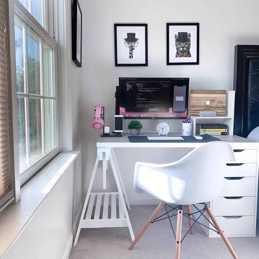 Minimalist workspace with a monitor, keyboard, mouse, and decor on a white desk featuring a white chair and window with blinds nearby