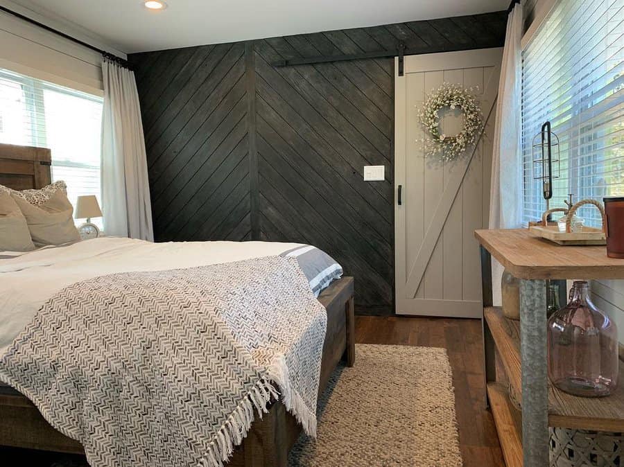 Bedroom with black chevron shiplap wall and barn door