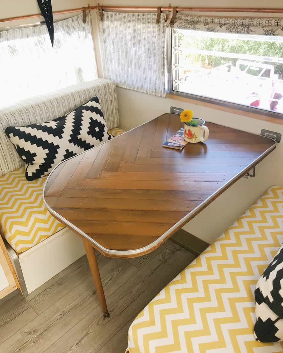 RV dining area with chevron seating and wood table