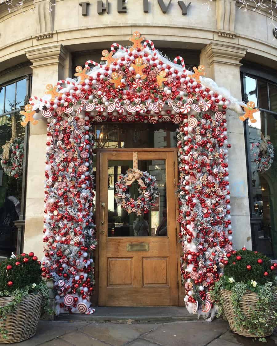 Christmas-themed doorway with colorful decorations and two festive planters