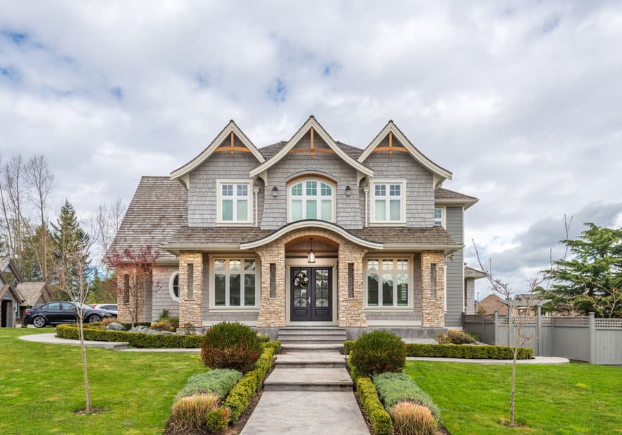 Elegant stone house with symmetrical front lawn