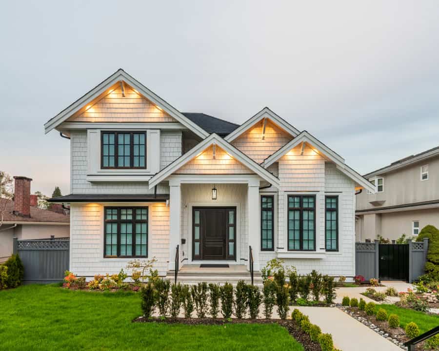 Traditional home with illuminated facade and manicured lawn