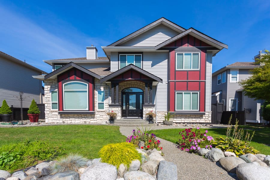 Two story house with rock garden and colorful accents