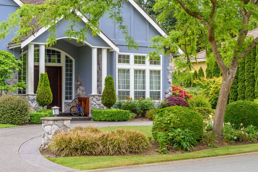 House with lush landscaping and curving driveway