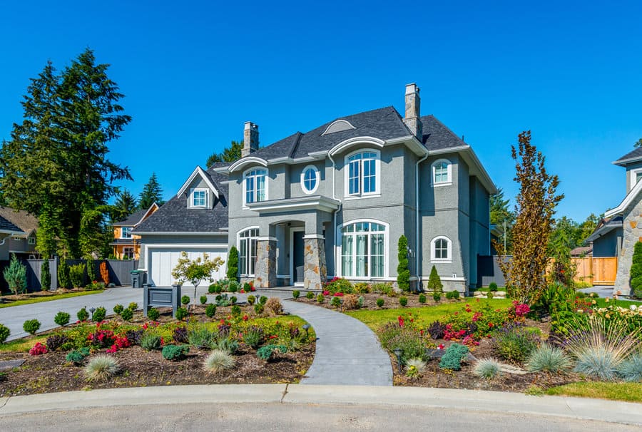 Grand house with curved walkway and colorful landscape