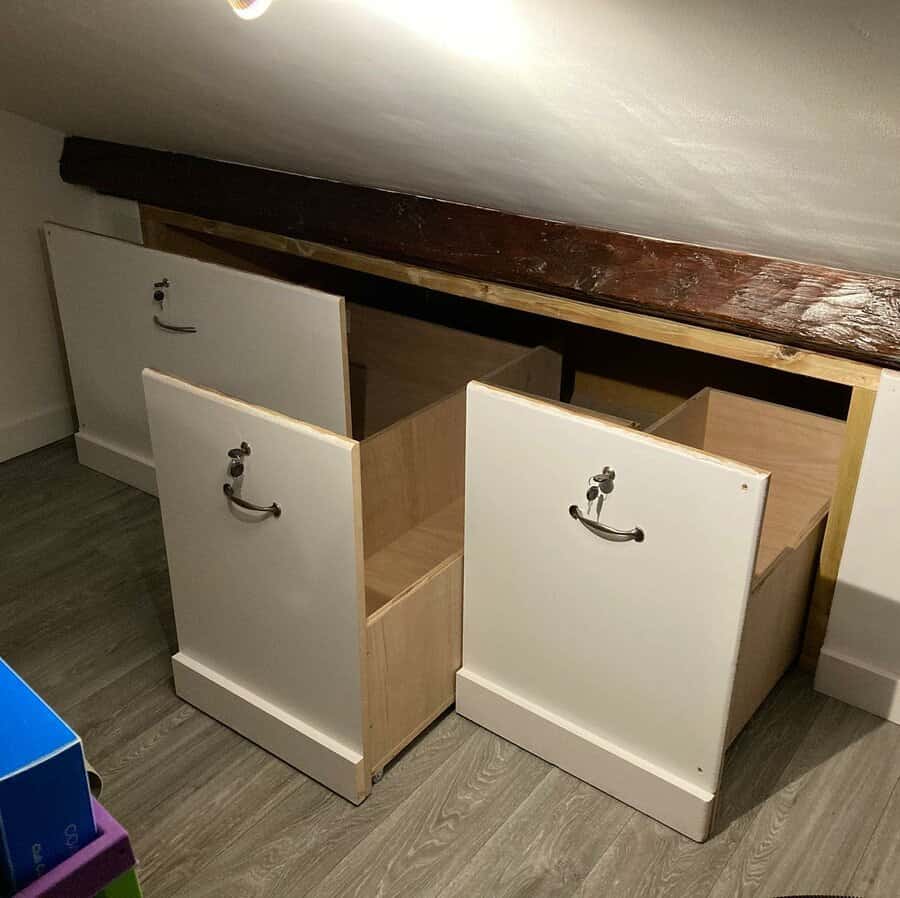 Custom-built pull-out storage drawers under a sloped attic ceiling, maximizing space while maintaining a clean and functional design.