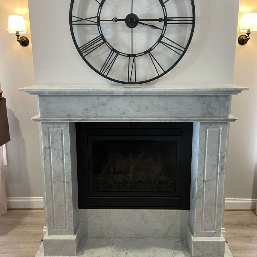 A sophisticated marble fireplace with clean lines, paired with a large black clock above, offering a timeless and elegant focal point