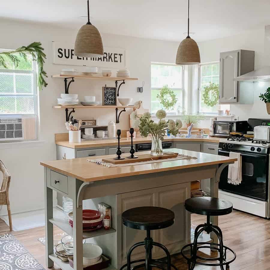 Charming farmhouse kitchen with a wooden breakfast bar, open shelving, rustic barstools, woven pendant lights, and soft neutral tones