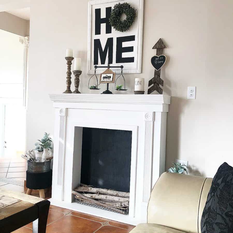 Living room with a white fireplace, "HOME" sign and decor on the mantel, potted plants, and beige walls