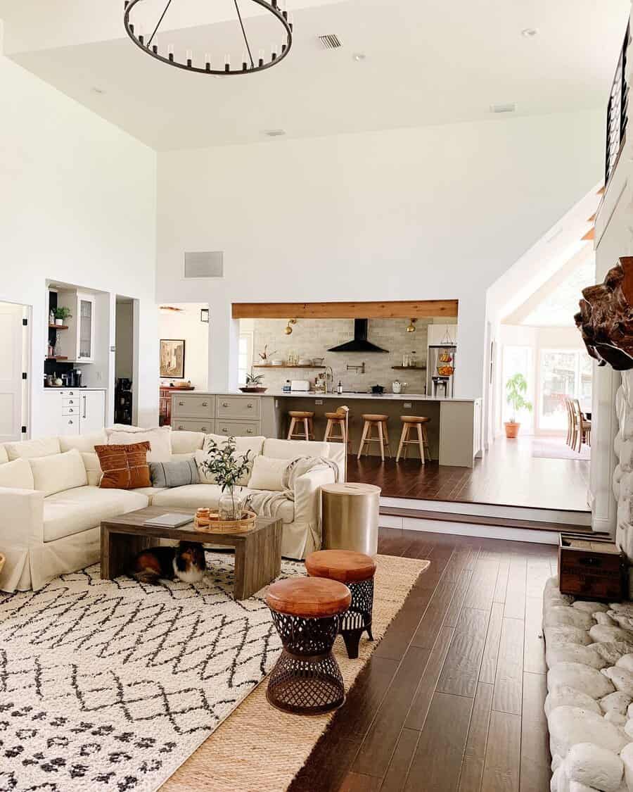 Open-concept living room and kitchen with modern rustic decor and high ceilings.