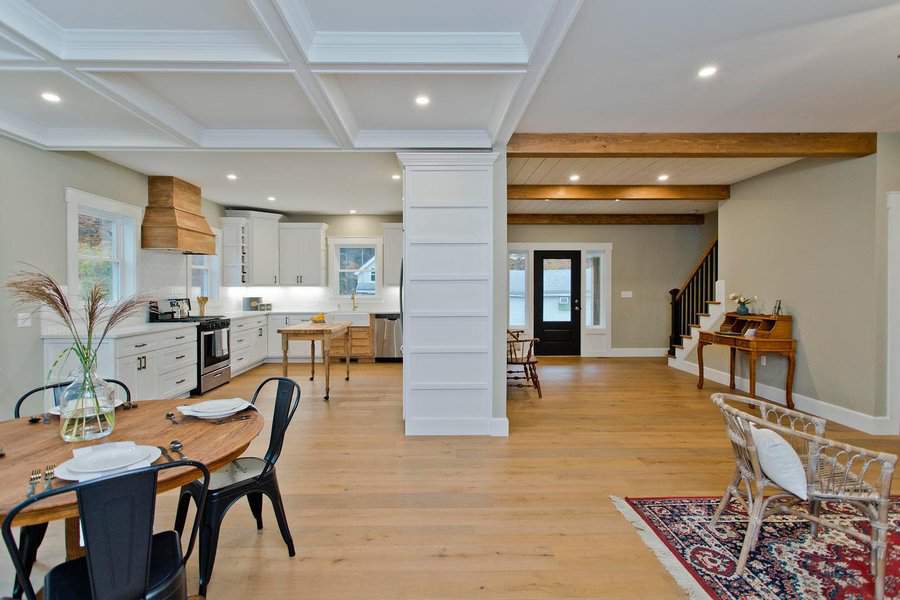 Bright farmhouse-style open floor plan with a white kitchen, wood accents, and cozy dining and living areas for a warm, inviting feel