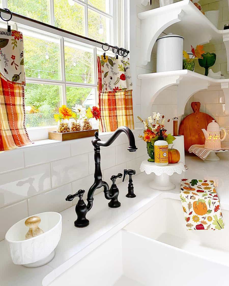 Charming farmhouse kitchen with a white apron sink, vintage black faucet, fall-themed decor, and plaid café curtains for a cozy touch