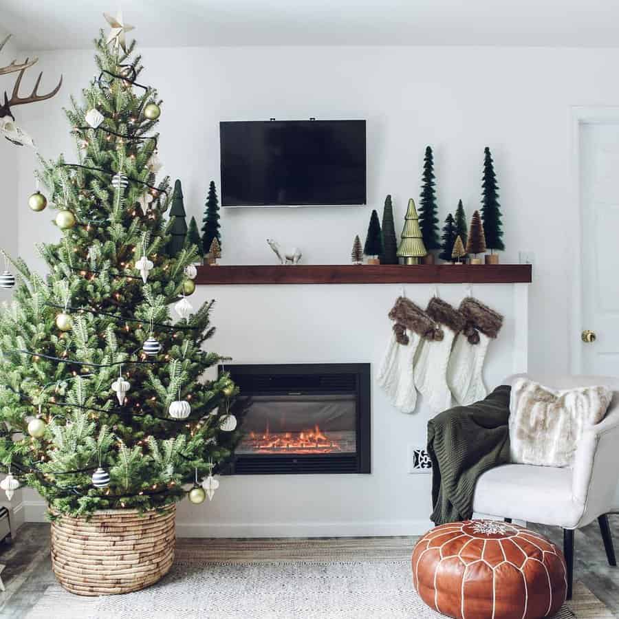 Christmas tree and stockings by a fireplace in a cozy, decorated living room