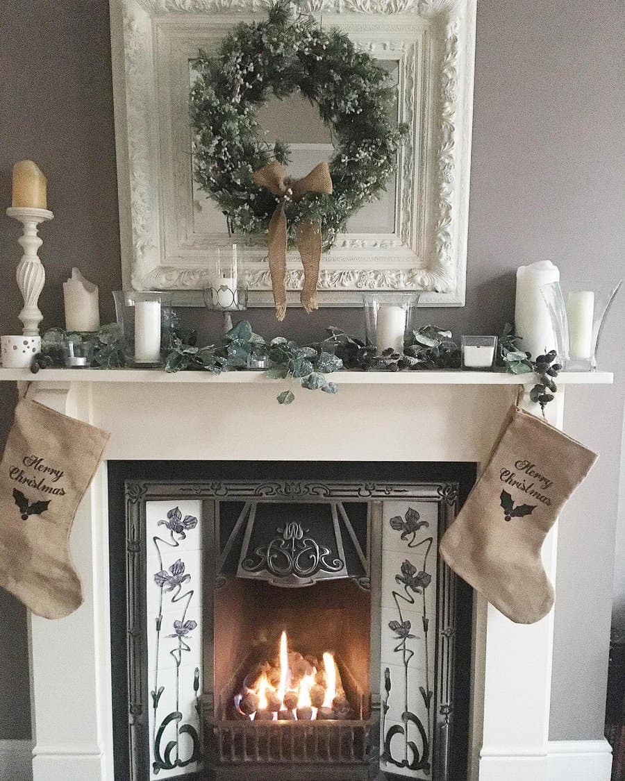 A cozy fireplace decorated for Christmas with stockings, candles, and a wreath