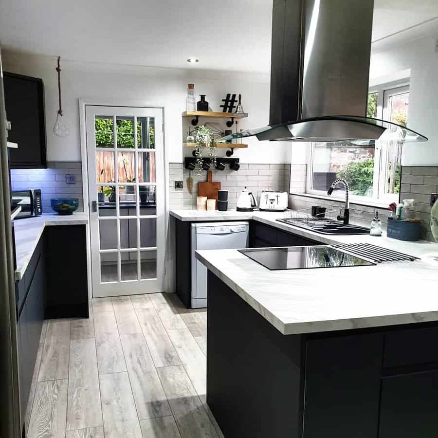 Light wood-look tile flooring adds warmth and contrast to this modern black-and-white kitchen, creating a sleek yet inviting atmosphere