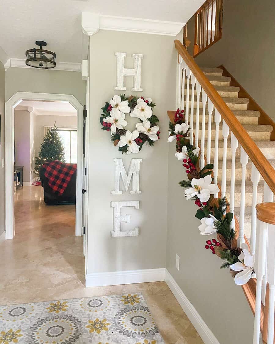 Christmas decorations with flowers and greenery on stairs and a "HOME" sign on the wall