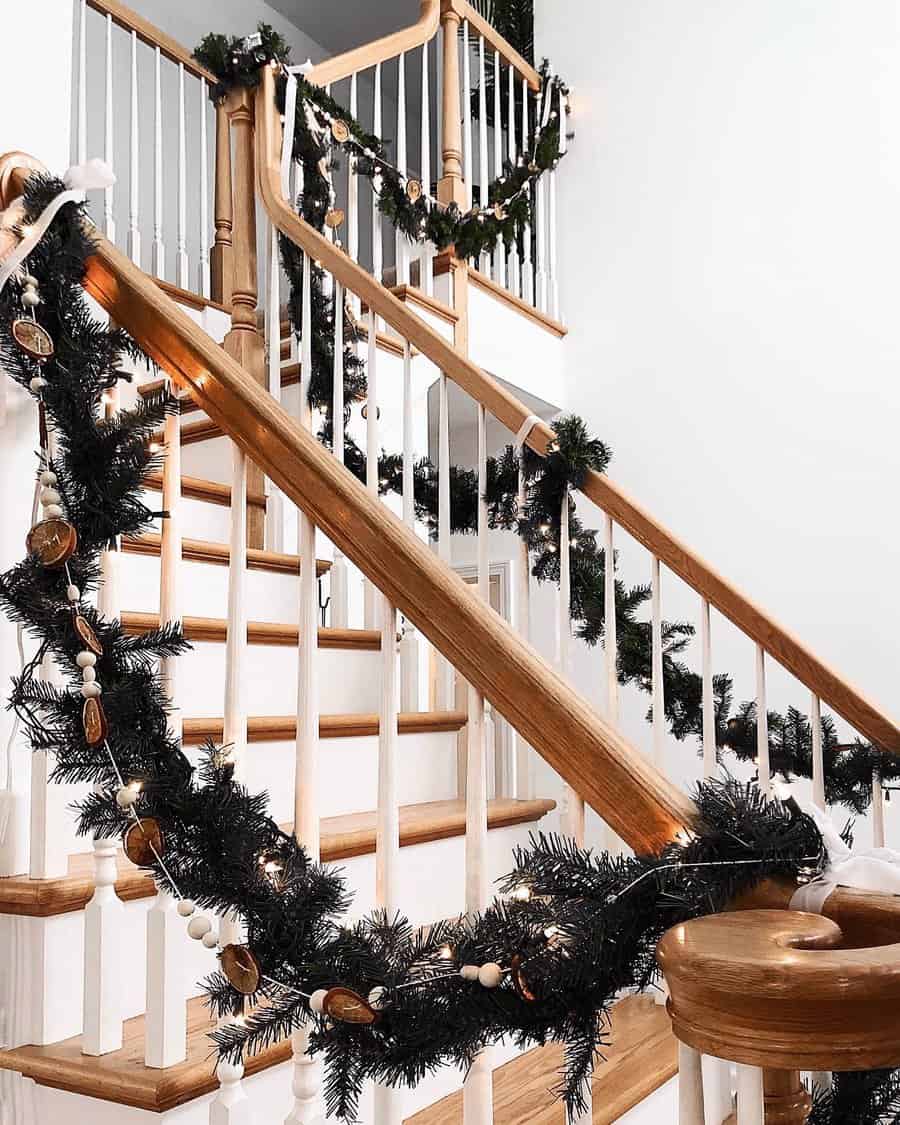 A wooden staircase decorated with festive garlands and lights for the holidays