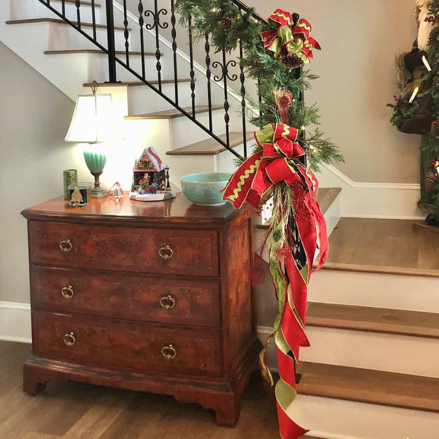 Decorated staircase and wooden dresser with holiday decor in a cozy home