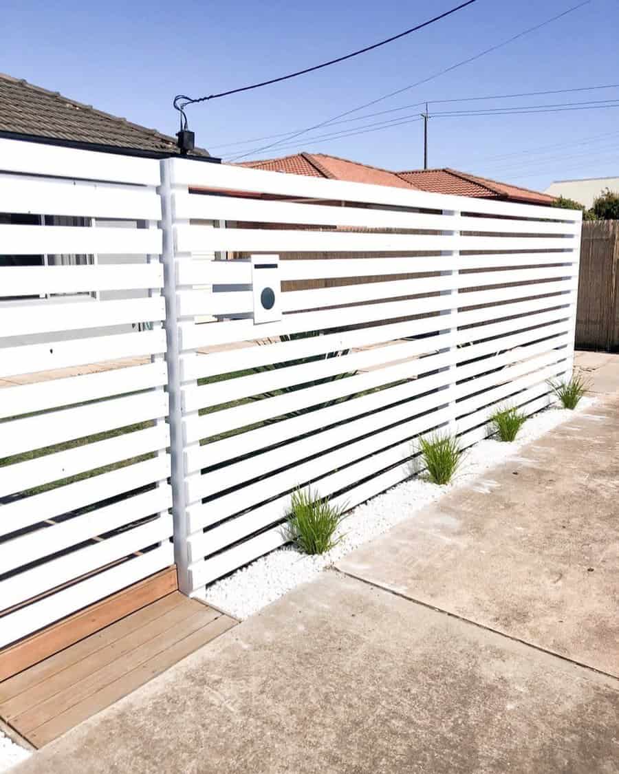 Modern white horizontal slat fence with landscaping