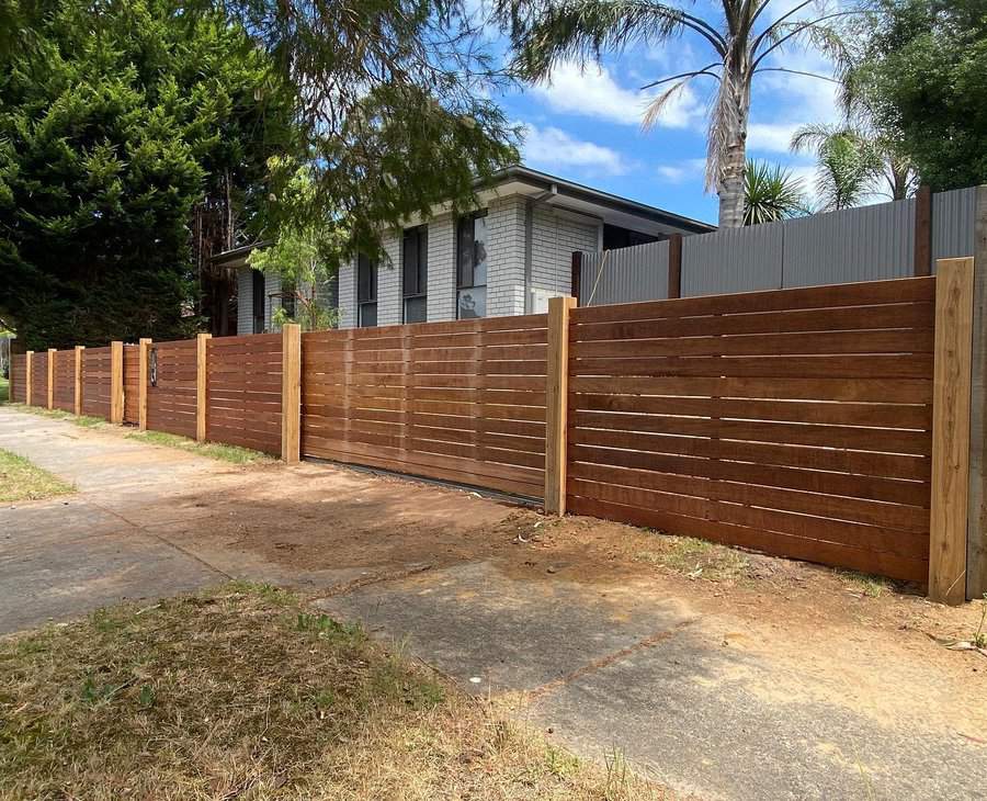 Street view of a house with a new wooden slat fence