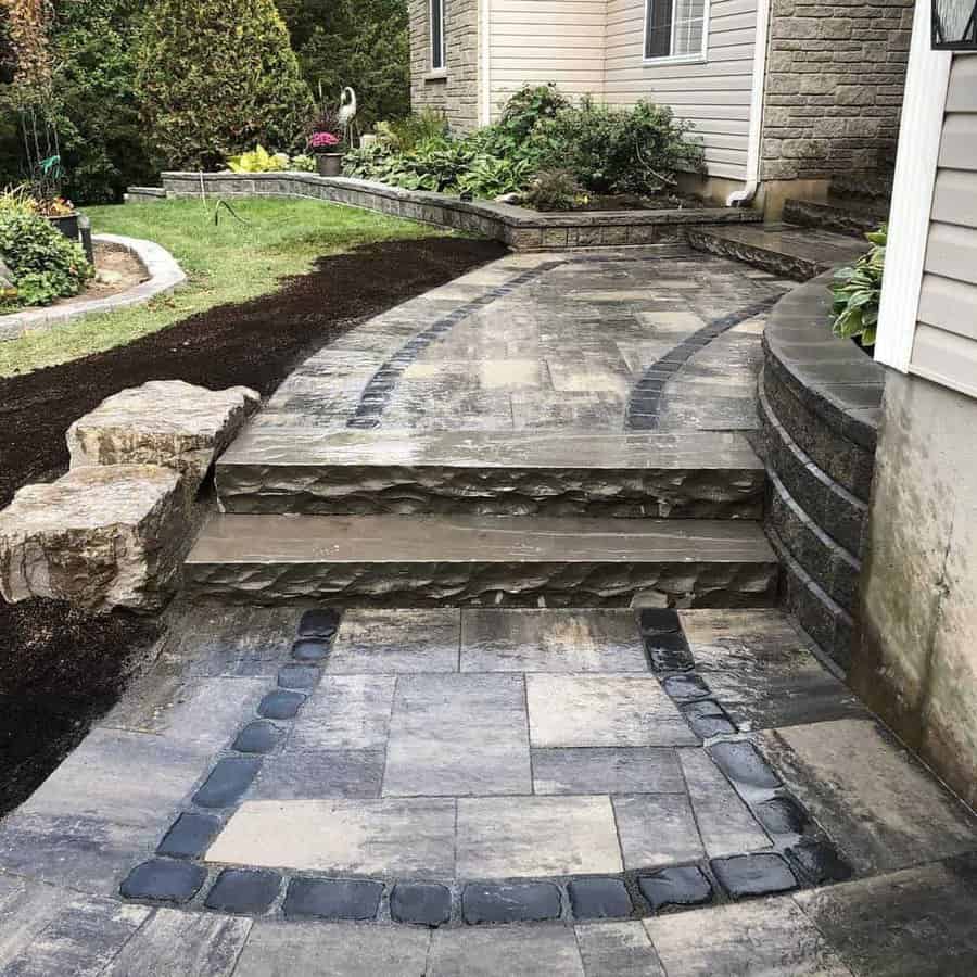 Curved stone driveway with steps and landscaping