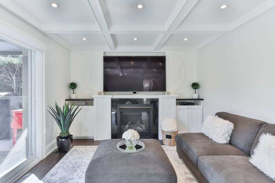 Elegant white living room with gray sofa and fireplace