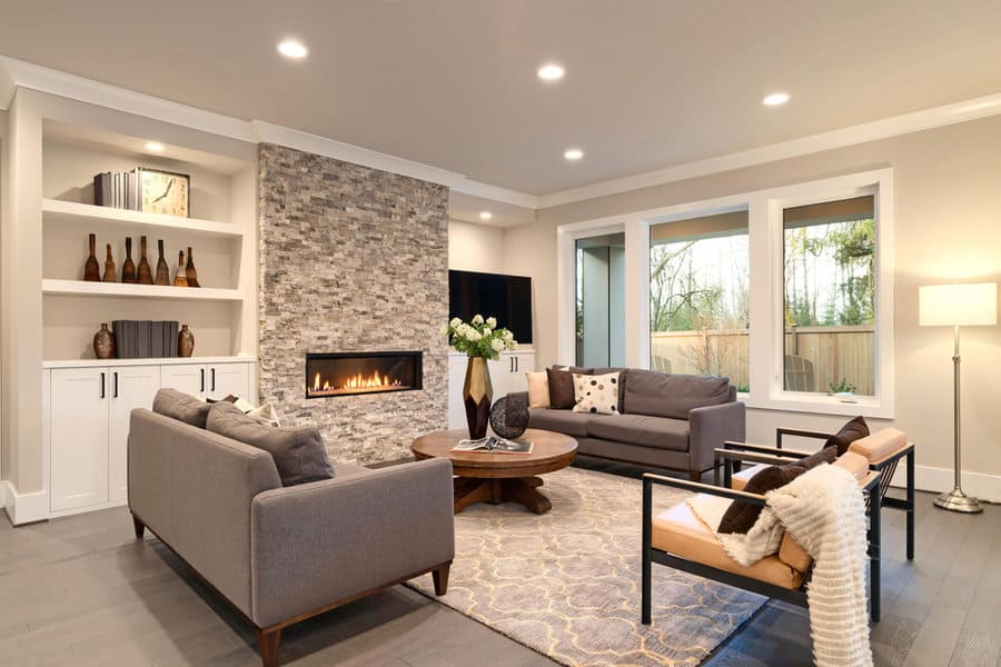 Modern living room with stone fireplace and built in shelves