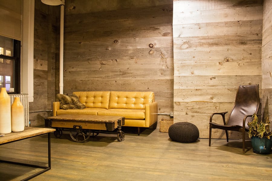 Urban rustic living area with wooden walls and mustard sofa