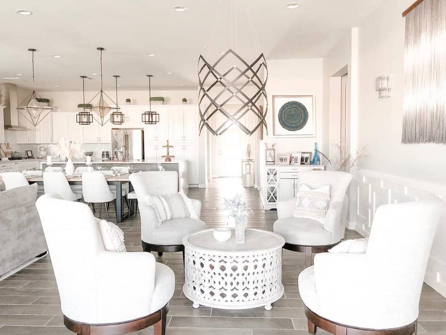 Elegant open floor plan with a neutral palette, modern chandeliers, cozy seating, and a spacious kitchen with geometric pendant lighting