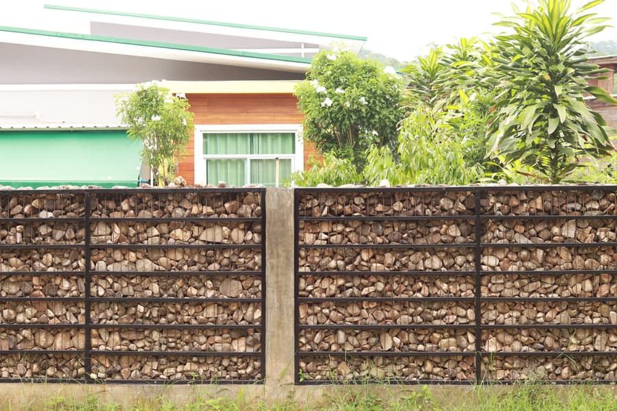 Gabion wall with tropical greenery backdrop