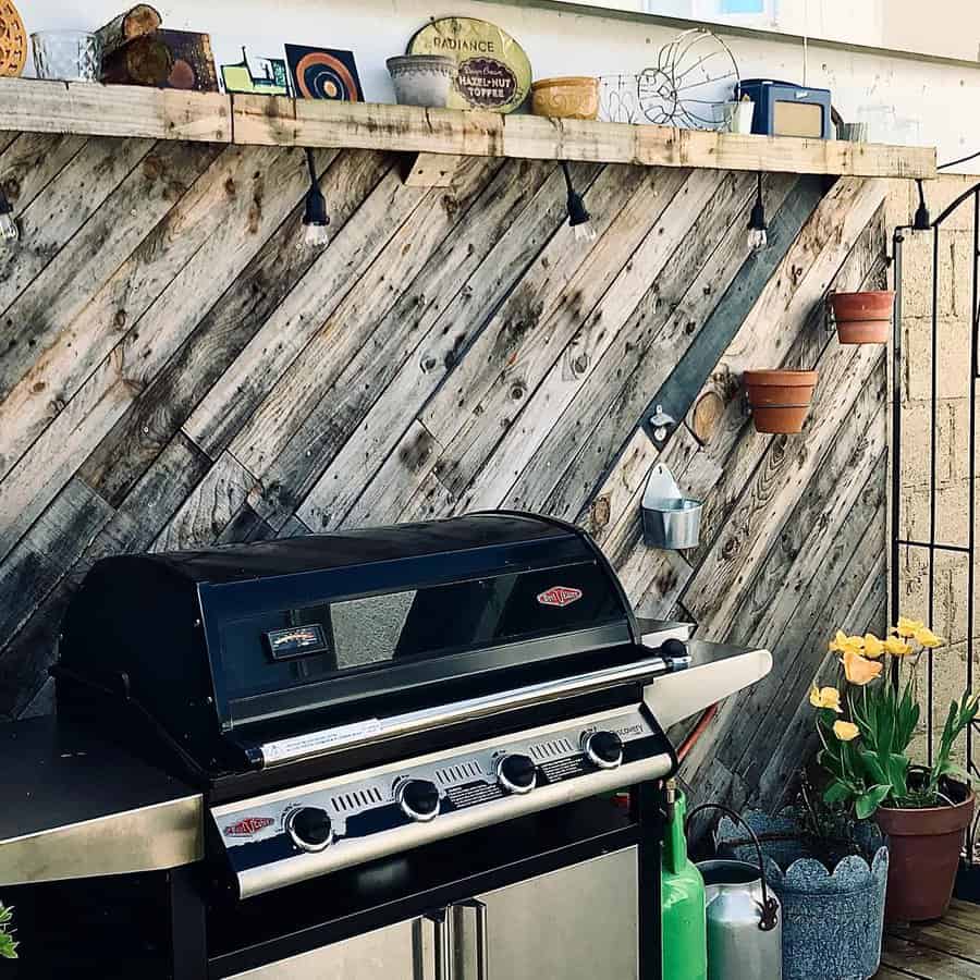 Outdoor grill area with rustic pallet wall backdrop