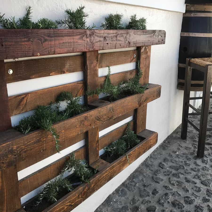 Pallet herb planter mounted on outdoor white wall