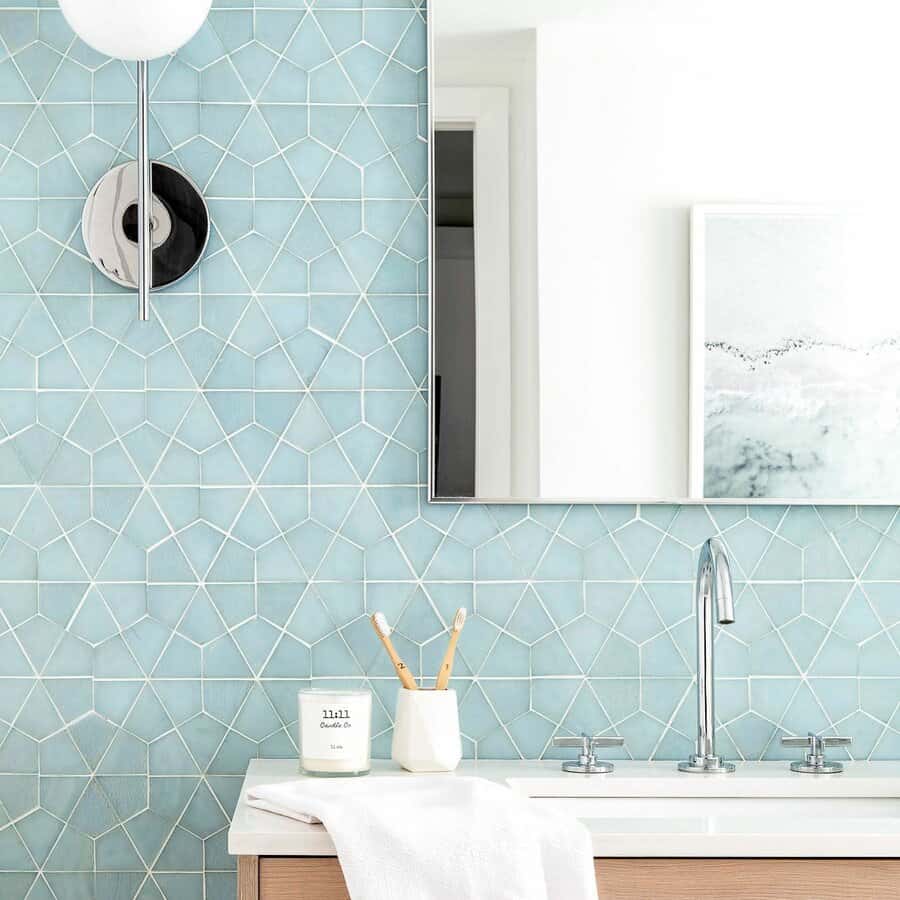 Bright bathroom with soft blue geometric tile backsplash, sleek chrome fixtures, and light wood vanity for a fresh, modern look.