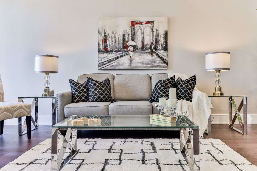 Elegant gray sofa with art and mirrored side tables