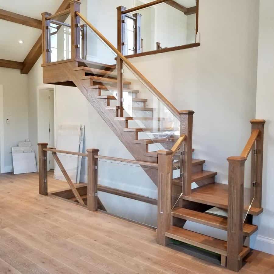 Staircase with glass panels and wooden railings