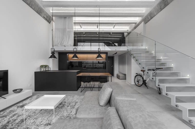 Minimalist living room with glass stair railing