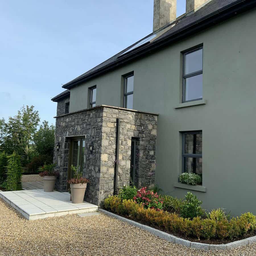 Stone clad home with gravel and shrub garden