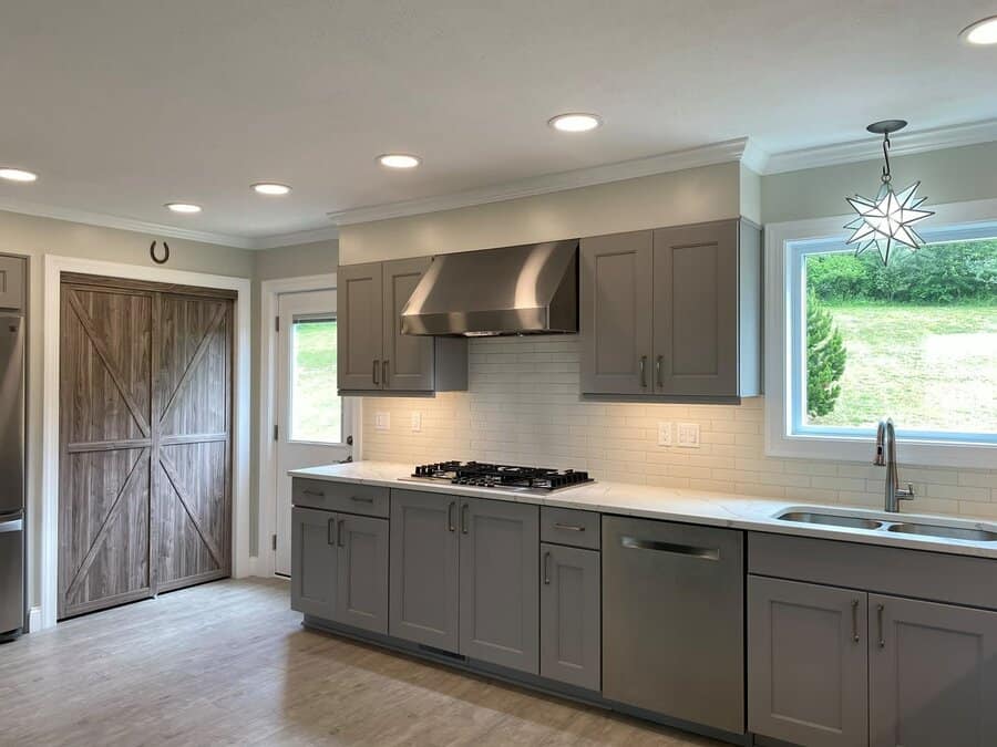 Spacious kitchen with grey cabinets and barn door