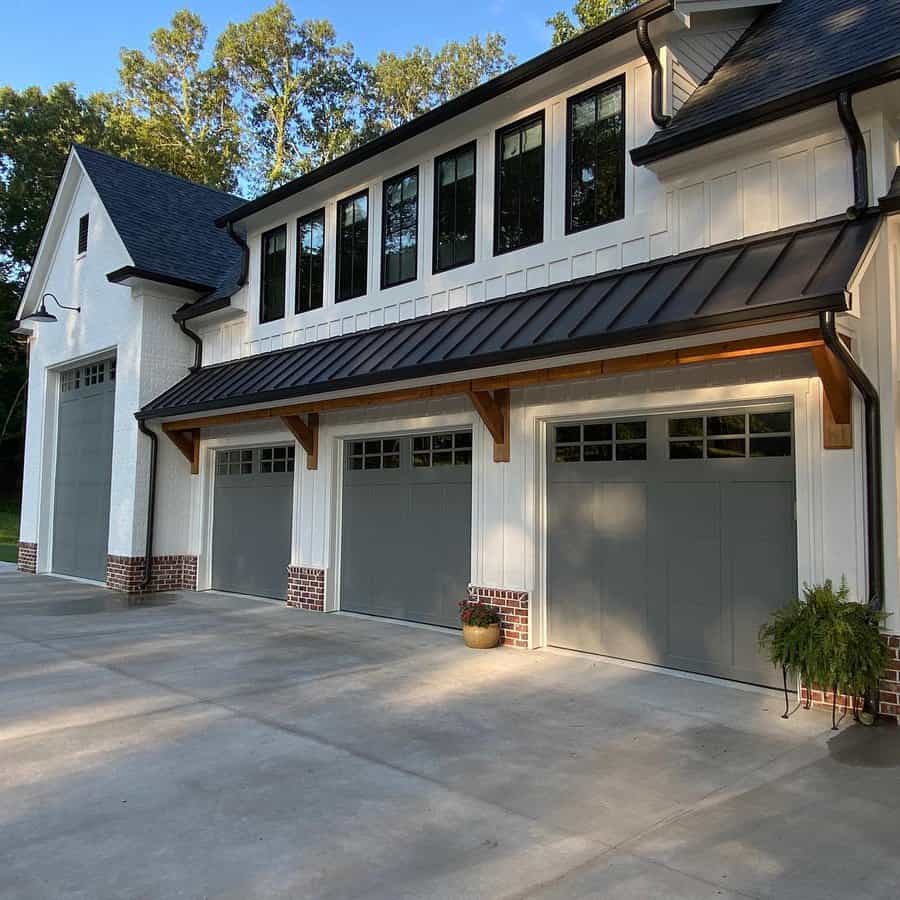 Traditional farmhouse with grey garage doors and brick accents