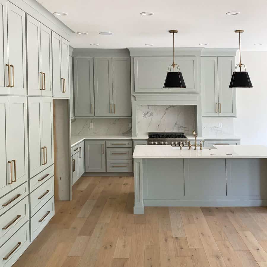 muted sage kitchen cabinet with gold fixtures