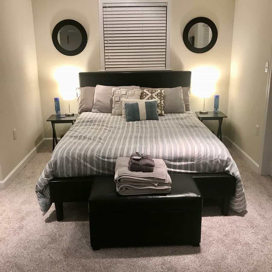 Modern bedroom with striped bedding and leather bench