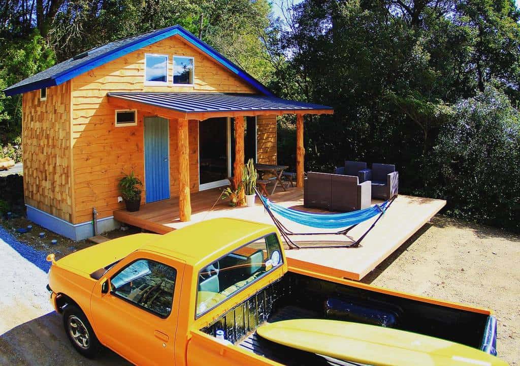 A small wooden house with a hammock outside