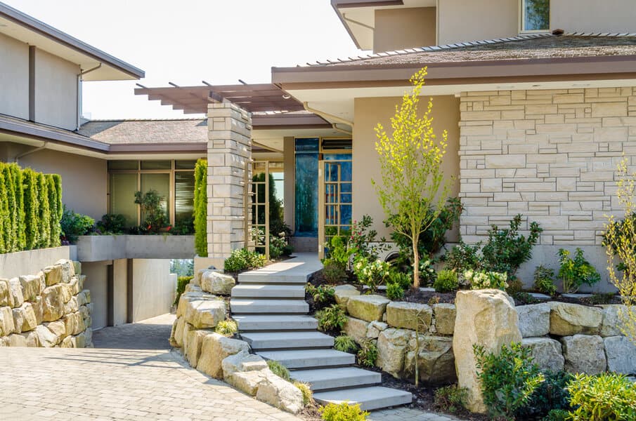 Modern entryway with stone steps and landscaped beds