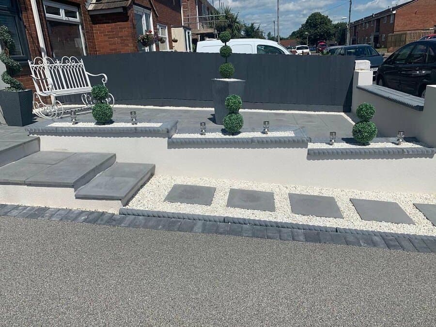 Contemporary hardscape with topiary and seating area