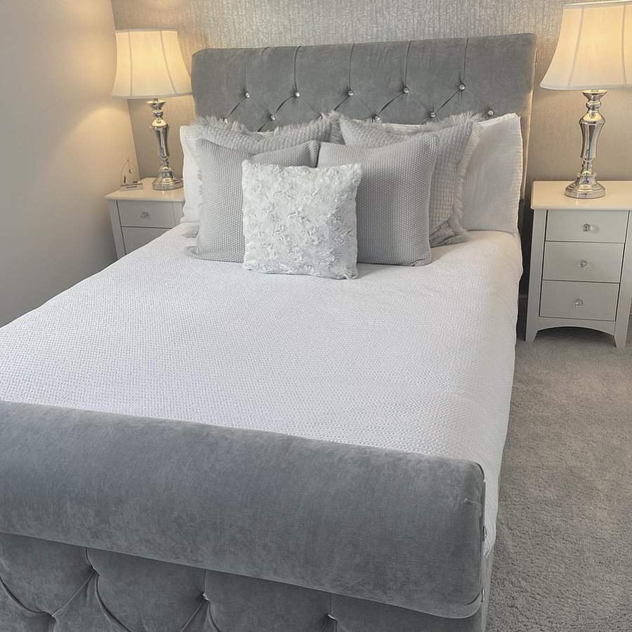 Neutral toned bedroom with tufted headboard and elegant lamps