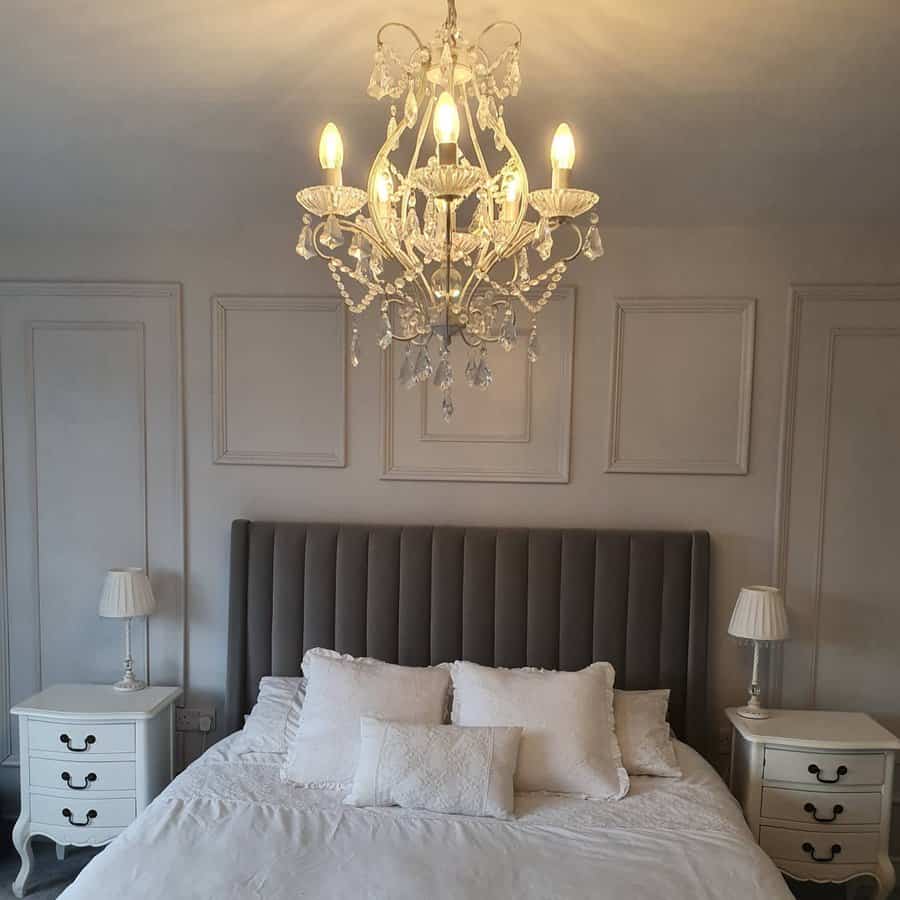 Elegant grey bedroom with crystal chandelier and paneled walls