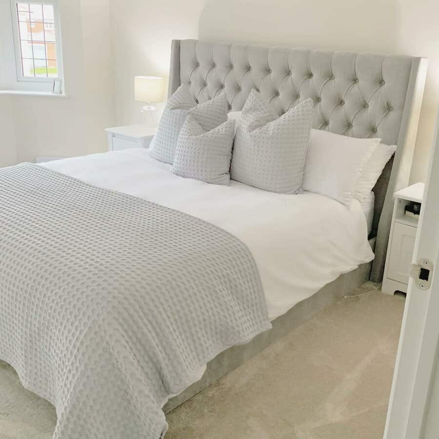 Cozy bedroom with plush grey headboard and textured bedding