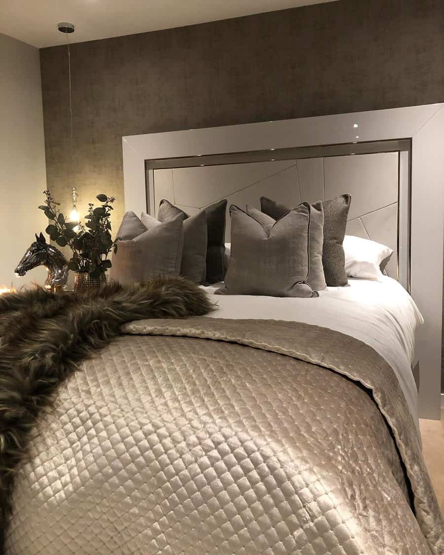 Warmly lit bedroom with mirrored headboard and luxurious textures