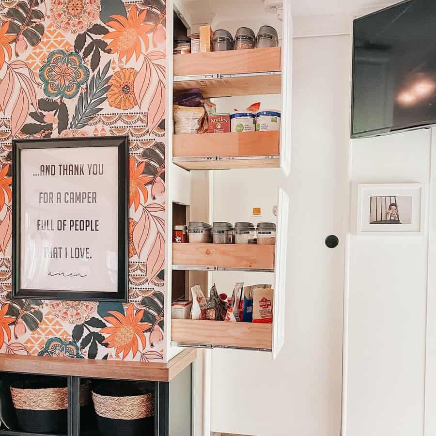 A creative hidden pantry with pull-out shelves, seamlessly integrated into a vibrant, floral-wallpapered space for stylish and efficient storage